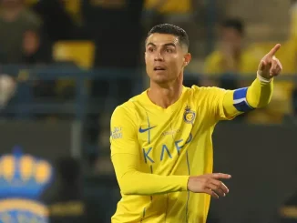 Cristiano Ronaldo em campo pelo Al-Nassr, vestindo uniforme amarelo e apontando durante o jogo.