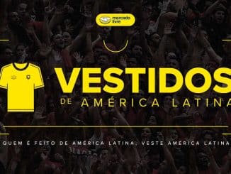 Imagem promocional da campanha "Vestidos de América Latina" pelo Mercado Livre, exibindo uma multidão de torcedores em êxtase com destaque para uma camisa de futebol amarela e o logo do Mercado Livre. O slogan diz: "Quem é feito de América Latina, veste América Latina".