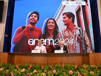 Autoridades do MEC e INEP em coletiva de imprensa sobre o ENEM 2024, com jovens estudantes ao fundo em um painel digital.