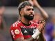 Gabigol, jogador do Flamengo, aplaude os torcedores em um gesto de despedida. Ele veste a camisa rubro-negra e olha emocionado para a torcida.