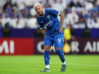 Neymar, com expressão de dor, segurando a coxa durante partida pelo Al-Hilal, vestindo o uniforme azul do clube.