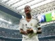 Vini Jr. comemorando intensamente em campo após marcar gol pelo Real Madrid, com o placar de 3 a 0 ao fundo.
