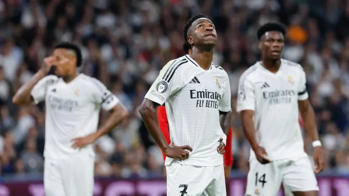 Vinícius Júnior e jogadores do Real Madrid mostram expressão de frustração após derrota para o Milan na Champions League.