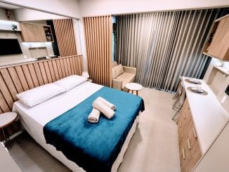 Studio mobiliado com cama de casal, sofá e cozinha integrada no Barra Conceito