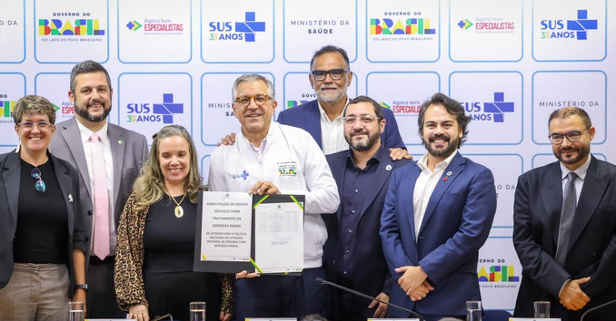 Autoridades do Ministério da Saúde segurando documento de habilitação de serviços para tratamento de doenças raras.