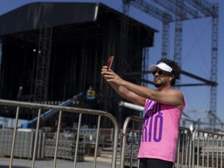 Foto da estrutura metálica do palco sendo montada na areia da Praia de Copacabana por operários.