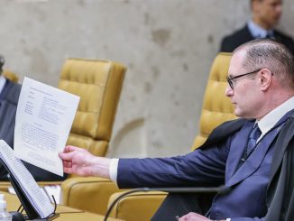 O ministro Cristiano Zanin sentado em sua cadeira no plenário do STF, vestindo toga preta.