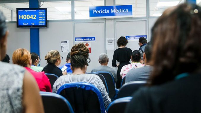 Fachada externa de uma agência do INSS com a logomarca oficial e portão de entrada.